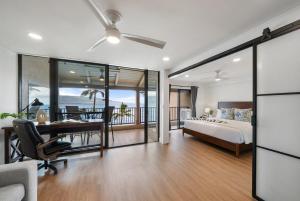 a bedroom with a bed and a desk and a table at Lauloa 403 · LOA 403 Fully Remodeled Direct Oceanfront 2BD in Wailuku +42 photos