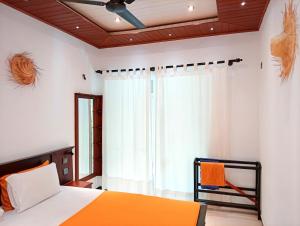 une chambre avec un lit et une fenêtre dans l'établissement Happy Three Holiday Homes, à Hikkaduwa