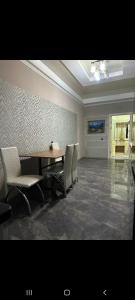 a dining room with a table and chairs at Раззаков in Bishkek