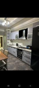 a kitchen with stainless steel appliances and a table at Раззаков in Bishkek