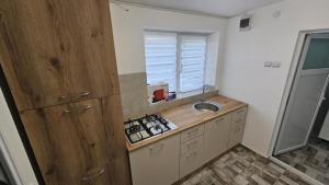 a kitchen with a counter and a sink and a window at Garsoniera in Craiova