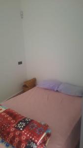 Un dormitorio con una cama con una manta encima. en sweet area, en Mirleft