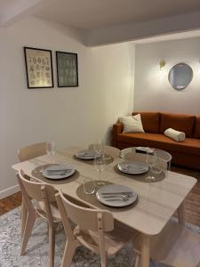 a dining room with a table and chairs and a couch at Appartement chic & cosy - 6 couchages Angers in Angers +3 photos