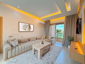 a living room with a couch and a table at Cocon Prestigia Argan avec piscine & parking in Marrakech