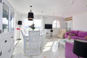 a living room with a table and a purple couch at Duplex Penthouse with Swimming Pool in La Herradura