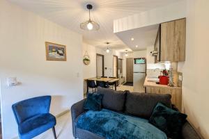 ein Wohnzimmer mit einem Sofa und einem blauen Stuhl in der Unterkunft Superbe appartement au pied des pistes in La Feclaz + 19 Fotos
