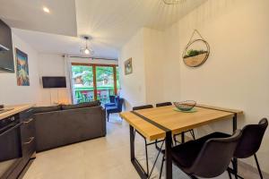 ein Wohnzimmer mit Tisch und Couch in der Unterkunft Superbe appartement au pied des pistes in La Feclaz