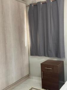 1 dormitorio con cortina de ducha y armario de madera en Maneph, en Chilanga