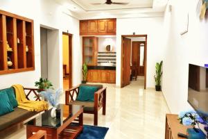 a living room with a couch and a table at PALM GROVE By D2V in Cochin +14 photos
