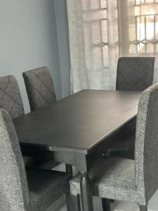 Una mesa de madera con cuatro sillas alrededor. en Maneph, en Chilanga