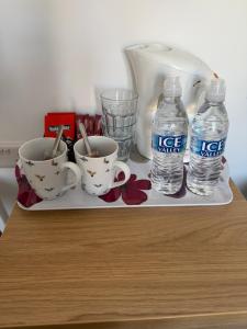 ein Tablett mit zwei Tassen und zwei Flaschen Wasser in der Unterkunft The Gallery in Lancing