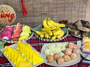 una tavola piena di diversi tipi di frutta e prodotti da forno di Tam Coc Sky Bungalow a Ninh Binh