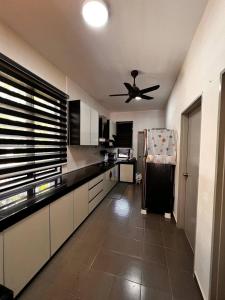 a kitchen with a ceiling fan and a refrigerator at TF Homestay in Banting