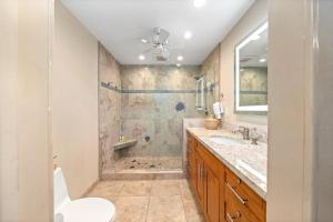 a bathroom with a sink and a shower and a toilet at Kulakane 310 · KK 310 Updated BeachFront 2BD w AC Pool in Kahana +47 photos