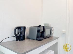 a counter with a microwave and a toaster and a coffee pot at Le Spacieux, Gare et Centre, Idéal Pro in Saint-Quentin +5 photos