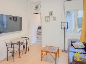 a living room with a table and chairs and a tv at Le Spacieux, Gare et Centre, Idéal Pro in Saint-Quentin