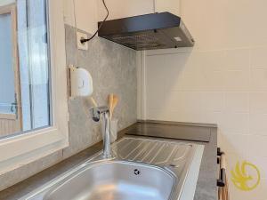 a kitchen with a sink and a hood at Le Spacieux, Gare et Centre, Idéal Pro in Saint-Quentin