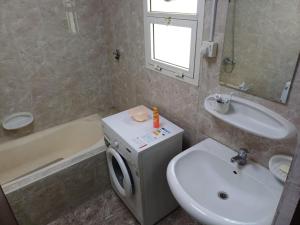 Un baño con lavabo y lavadora. en Shared Studio in a marvel location and marvel furniture in Abu Dhabi Center, en Abu Dabi 42 fotos más
