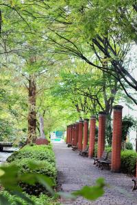 ein Park mit Bänken, einer Statue und Bäumen in der Unterkunft ザレジデンスホテル岡山 in Okayama