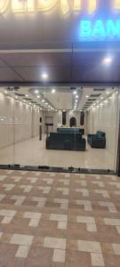 RāmnagarThe Holiday Inn的建筑物内一间摆放着沙发和标牌的房间