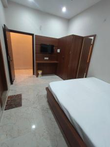 RāmnagarThe Holiday Inn的房间里有一张床和一台电视的卧室