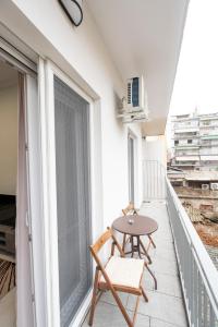 a balcony with a table and chairs and a window at Serra Modern Apt " Free Parking " Quiet " Near Center in Serres +25 photos