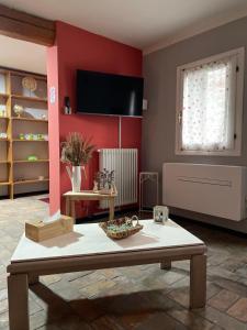 uma sala de estar com uma mesa e uma parede vermelha em Ca' Dei Sassi em Sequsino