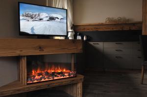 a living room with a tv and a fireplace at Borch Chalet - Exclusive Apartments in Livigno