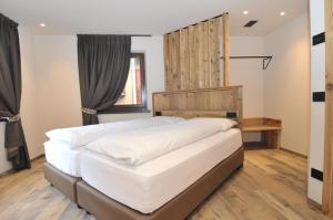 a bedroom with a large bed with a wooden headboard at Borch Chalet - Exclusive Apartments in Livigno