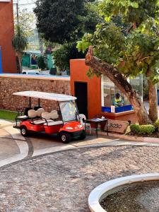 a small red golf cart parked in front of a building at Las Tortugas beach front condo in Khao Tao
