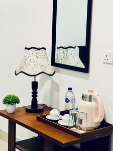 una mesa con una lámpara y una cafetera. en 4 Axes Ella, en Ella