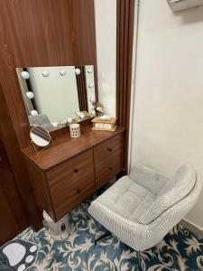 ein Ankleidezimmer mit einem Stuhl und einem Spiegel in der Unterkunft Luxury 2BR apartment near Muscat Mall in Ma‘ābīlah + 5 Fotos