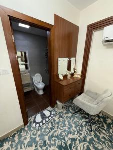 ein Badezimmer mit Toilette, Waschbecken und Spiegel in der Unterkunft Luxury 2BR apartment near Muscat Mall in Ma‘ābīlah