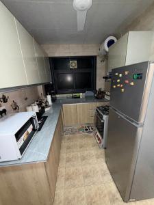 eine Küche mit einem Kühlschrank aus Edelstahl in der Unterkunft Luxury 2BR apartment near Muscat Mall in Ma‘ābīlah