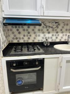 een keuken met een kookplaat en witte kasten bij Magnifique Studio in Mostaganem