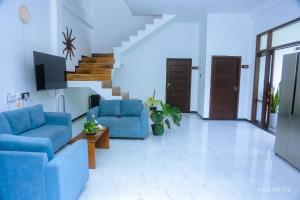 ein Wohnzimmer mit zwei blauen Sofas und einer Treppe in der Unterkunft Zeyora Mirissa in Mirissa