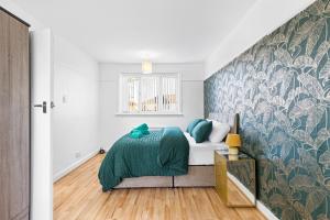 a bedroom with a bed and a wall mural at Comfy 3Bedroom Manchester Getaway in Manchester