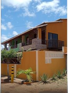 ein Haus mit einem gelben in der Unterkunft Duplex praia de camarupim in Nísia Floresta + 27 Fotos