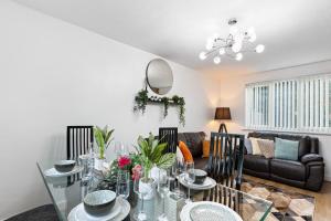 a living room with a glass table and chairs at Comfy 3Bedroom Manchester Getaway in Manchester