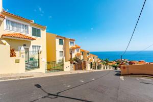 a street with houses and the ocean in the background at JPL - Preces Residential in Câmara de Lobos