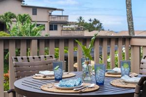 une table avec des assiettes de nourriture et une plante dessus dans l'établissement Kahana Sunset C1 · KSun C1 Gorgeous Ocean Views Family Vacation, à Kahana