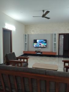 ein Wohnzimmer mit Couch und Flachbildfernseher in der Unterkunft Amaira Studio living - Coimbatore in Coimbatore