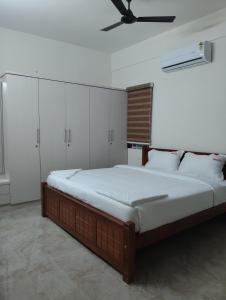 ein Schlafzimmer mit einem großen Bett und einem Deckenventilator in der Unterkunft Amaira Studio living - Coimbatore in Coimbatore