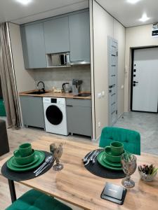 eine Küche mit einem Tisch und grünen Gerichten darauf in der Unterkunft Сейфулина 31 in Balqasch