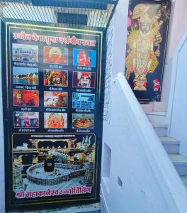 a wall with posters on it with a cake on it at Johari Heritage Home in Ujjain