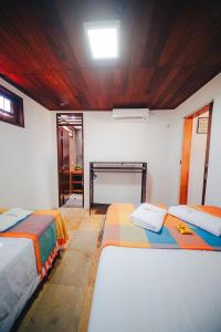 ein Zimmer mit zwei Betten und einem Tisch darin in der Unterkunft Praia Taíba in Taíba