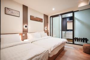 een slaapkamer met een groot bed met witte lakens bij Shipu Hotel in Pu-pien