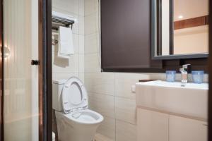 een badkamer met een wit toilet en een wastafel bij Shipu Hotel in Pu-pien +39 foto's