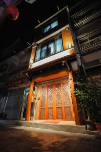 een gebouw met een oranje deur en ramen bij Shipu Hotel in Pu-pien