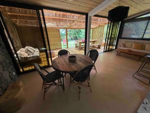 Un comedor con mesa y sillas de madera. en Villa GEORGETTE - Saint Gilles 50 M du lagon, en Saint-Paul